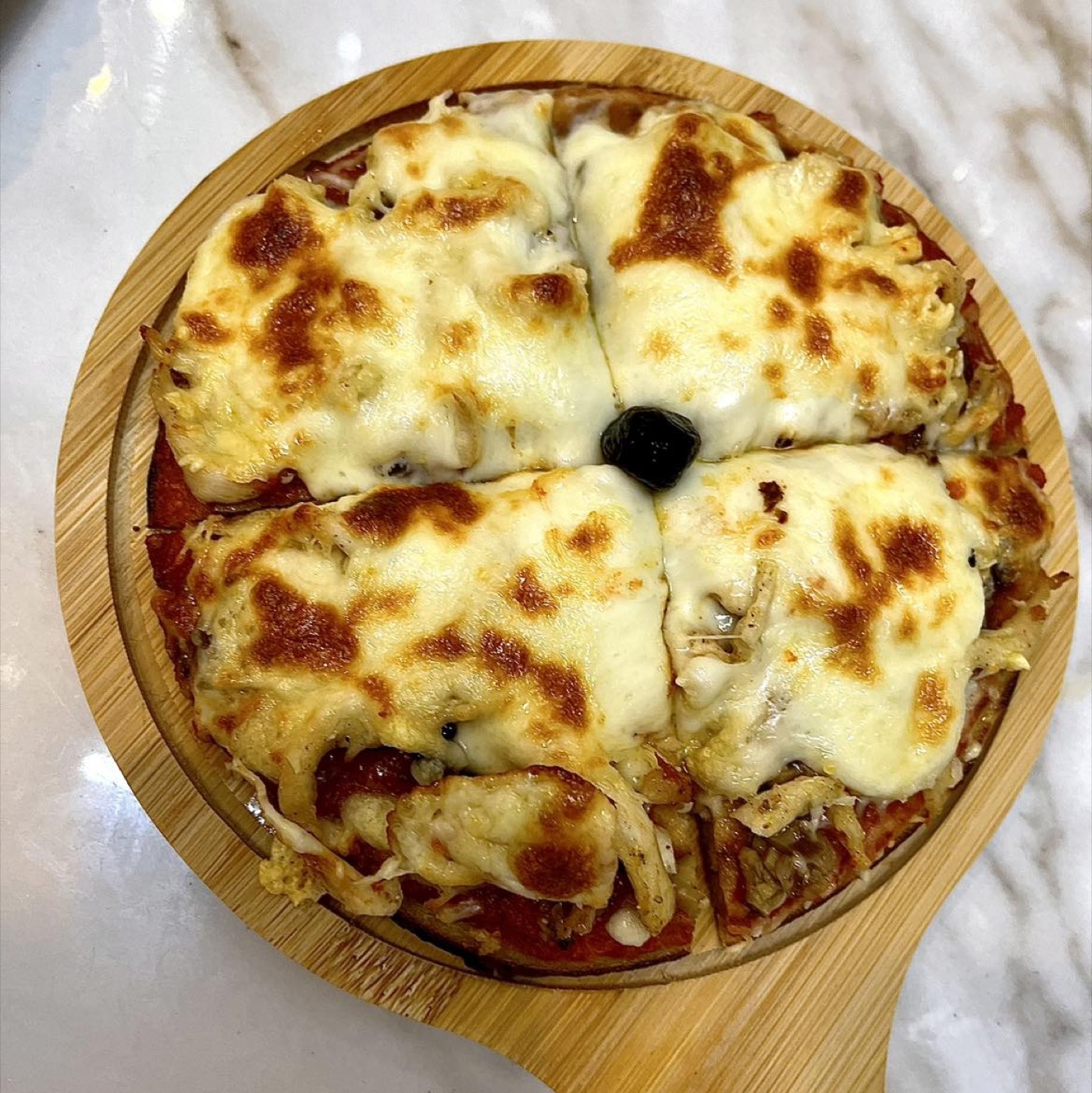 Pizza-crêpe gratinée servie sur une planche en bois